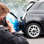 young male motorist involved in car accident calling insurance company or recovery service