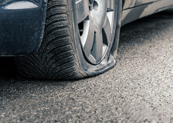 flat car tyre close up, punctured wheel